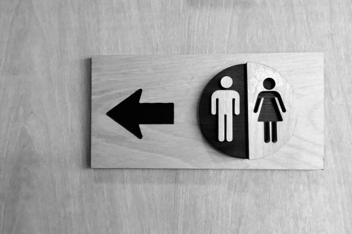 bathroom sign with arrow and male/female symbols