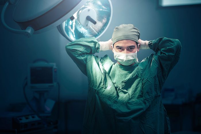 surgeon tying on face mask
