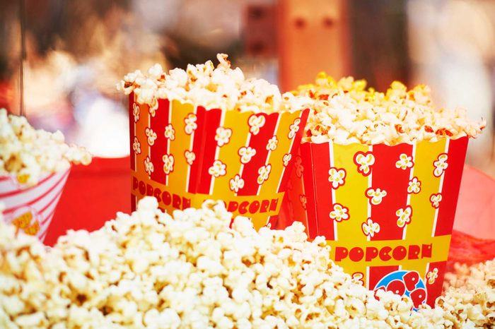 Bags of popcorn in red- and yellow-striped containers.