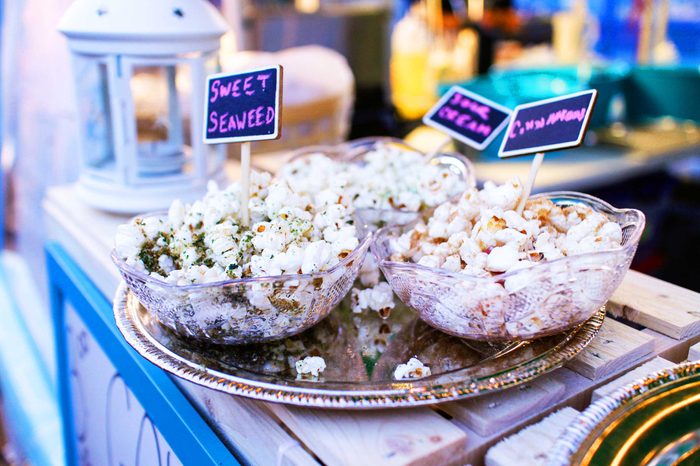 Tray containing three bowls of popcorn with different toppings, including cinnamon popcorn and sweet seaweed popcorn