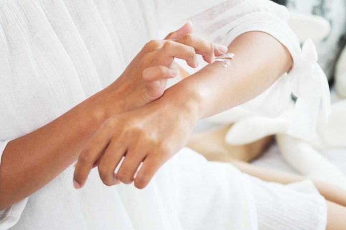 woman applying lotion to her arm