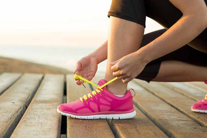 woman tying running shoe