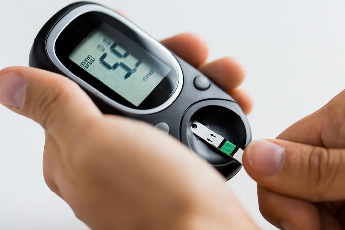 Person checking their blood sugar with a glucose monitor.