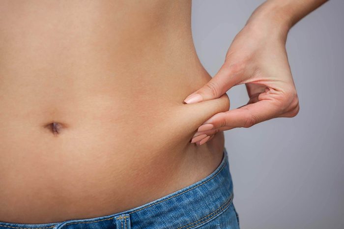 Woman pinching skin on hip