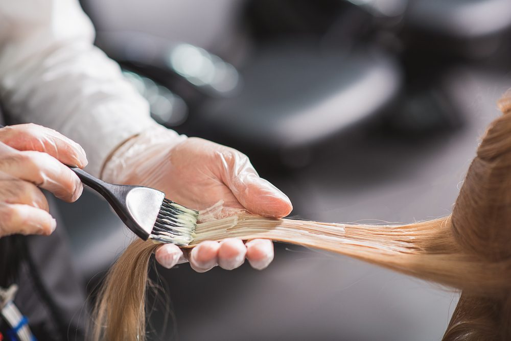 hands in gloves dying strands of hair