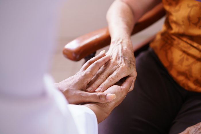 person holding elderly woman's hand