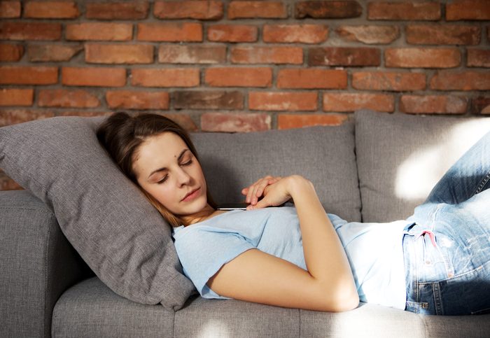 Beautiful young woman is sleeping on couch.