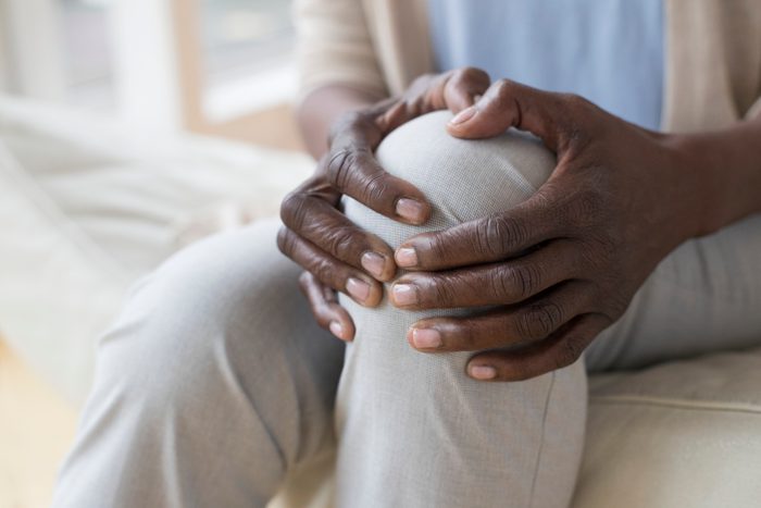 close up of woman holding knee from pain