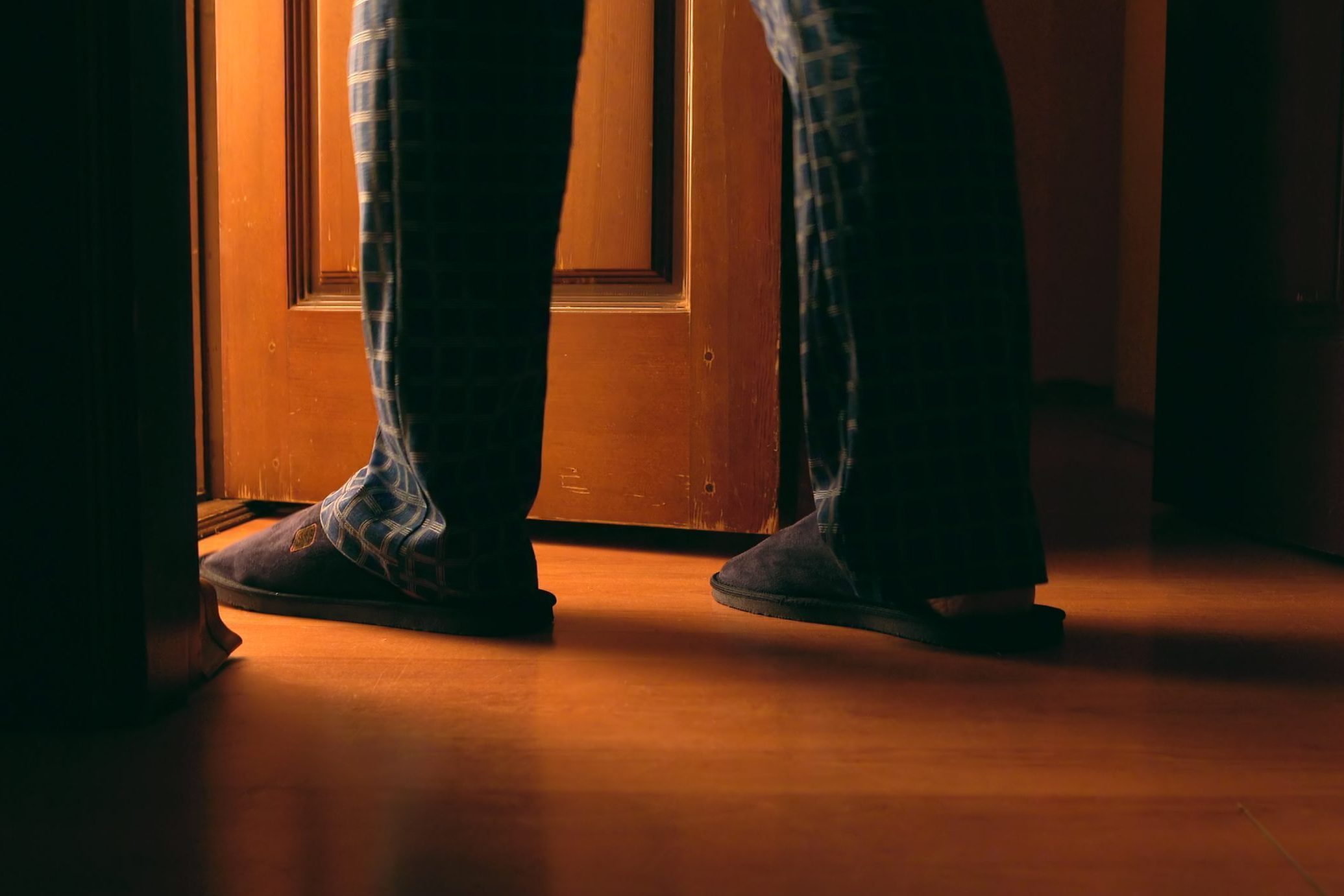 Adult man walking into bathroom at night